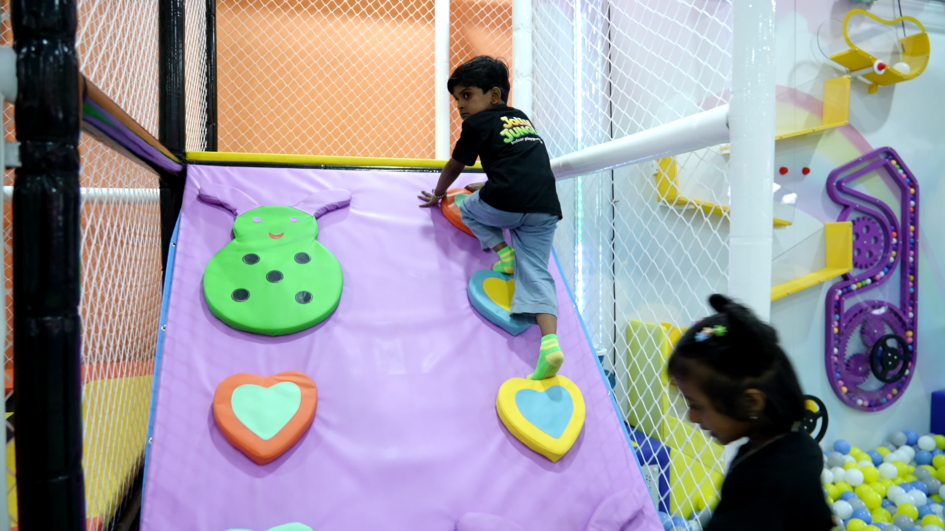 A young explorer climbing the padded play ramp